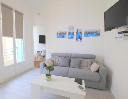 un salon avec un canapé et une table dans l'établissement Happyfew Le Miramar, à Nice