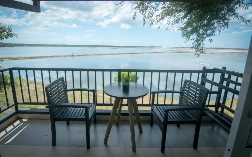 a table and chairs on a balcony with a view of the water at Jade Green Hotel Hambantota in Hambantota