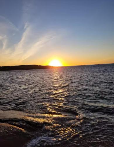 a sunset over a large body of water at The Roundhouse in Lettermullan