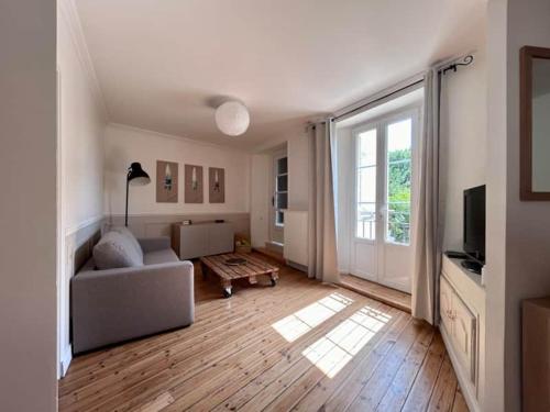 un salon avec un canapé et une grande fenêtre dans l'établissement Le Cocon Bayeusain x Parking by Melrose, à Bayeux