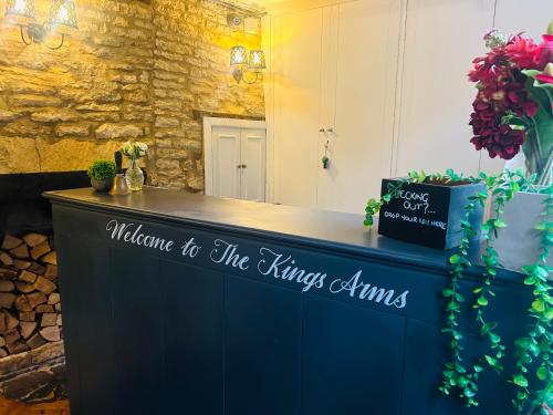 a blue counter with a sign that reads welcome to the kings armies at The Kings Arms Hotel in Stow on the Wold
