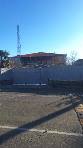 a parking lot with a white fence and a building at Tskaltubo-house in Tskaltubo