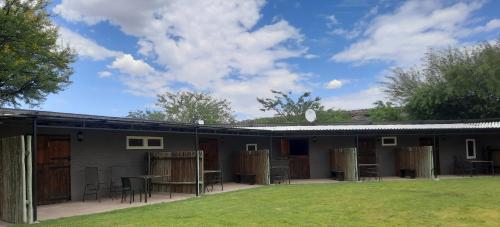 a building with a table and chairs in a yard at Teri-Lemveli Lodge in Beaufort West