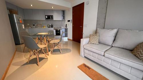 a living room with a couch and a kitchen at Hermoso Zona Norte Río in Rosario