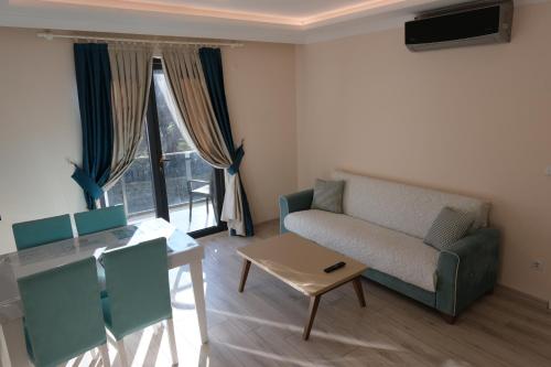 a living room with a couch and a table at Şahin Tepesi Suite Otel in Trabzon