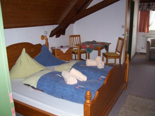 a bedroom with a large bed with blue sheets at Landgasthof Gotzenmühle in Lichtenau