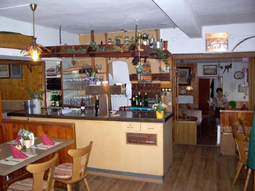 eine Küche mit einer Bar und einem Tisch mit Stühlen in der Unterkunft Landgasthof Gotzenmühle in Lichtenau