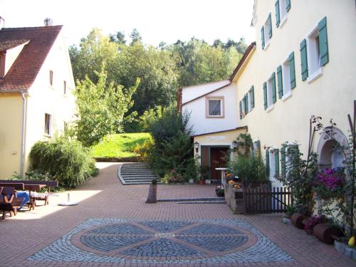 einen Innenhof in einem Haus mit einem Mosaik auf dem Boden in der Unterkunft Landgasthof Gotzenmühle in Lichtenau