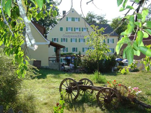 a large white house with a building in the background at Landgasthof Gotzenmühle in Lichtenau
