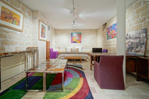 - un salon avec une table et un tapis coloré dans l'établissement Chez l'Antiquaire, un repaire Arty aux Puces de Saint-Ouen, à Saint-Ouen