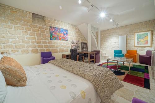 - une chambre avec un lit et des chaises colorées dans l'établissement Chez l'Antiquaire, un repaire Arty aux Puces de Saint-Ouen, à Saint-Ouen