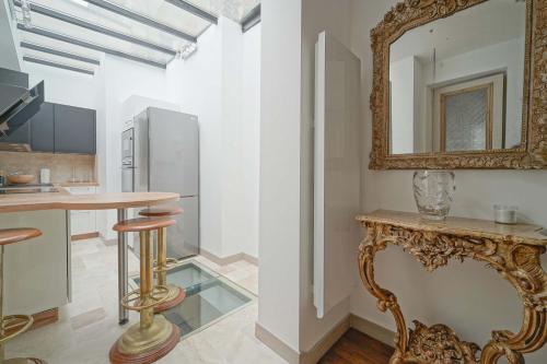 une cuisine avec un miroir et une table avec des tabourets dans l'établissement Chez l'Antiquaire, un repaire Arty aux Puces de Saint-Ouen, à Saint-Ouen