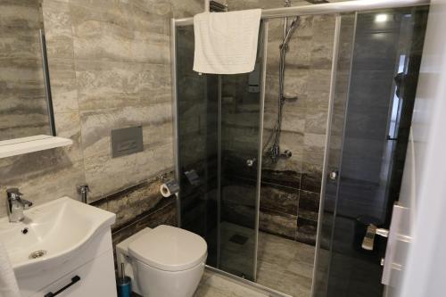a bathroom with a shower and a toilet and a sink at Şahin Tepesi Suite Otel in Trabzon