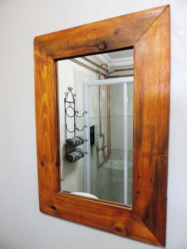 a mirror hanging on a wall in a bathroom at Teri-Lemveli Lodge in Beaufort West
