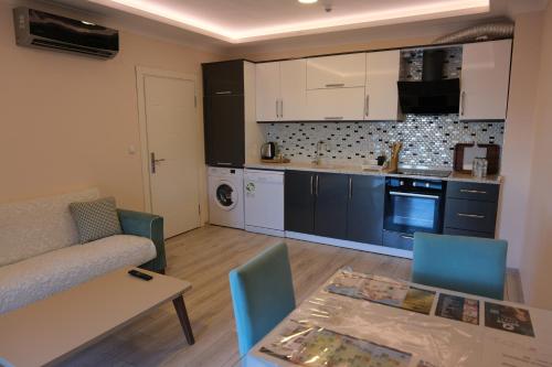 a small living room with a table and a kitchen at Şahin Tepesi Suite Otel in Trabzon