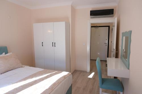 a bedroom with a bed and a blue chair at Şahin Tepesi Suite Otel in Trabzon