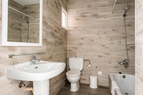 Un baño con un lavabo blanco y un inodoro. en Apartamentos Alta Galdana Playa by Escape Home, en Cala Galdana