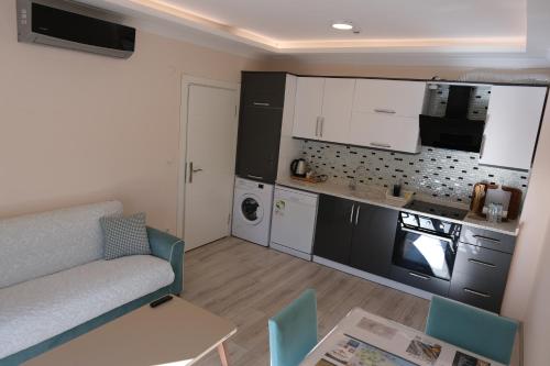 a small kitchen and living room with a couch and a table at Şahin Tepesi Suite Otel in Trabzon
