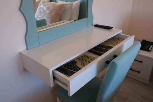 a white desk with a mirror and a blue chair at Şahin Tepesi Suite Otel in Trabzon