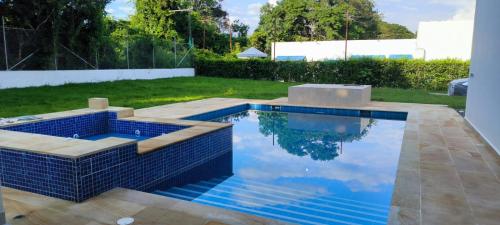 una piscina con piastrelle blu in un cortile di Casa campestre en Melgar a Melgar