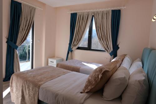 a bedroom with two beds and a large window at Şahin Tepesi Suite Otel in Trabzon