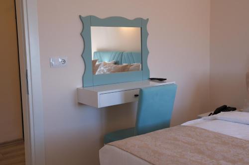 a bedroom with a vanity with a mirror next to a bed at Şahin Tepesi Suite Otel in Trabzon