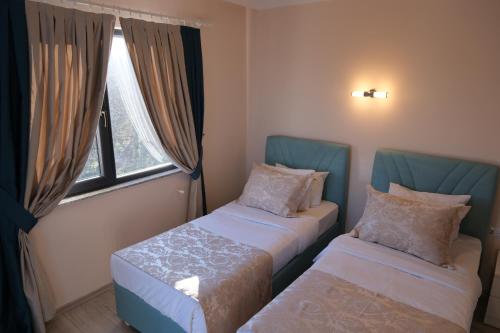 a room with two beds and a window at Şahin Tepesi Suite Otel in Trabzon