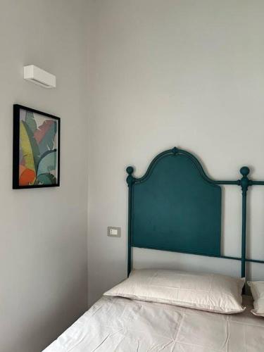 a bed with a blue headboard in a bedroom at Casa I Merletti in Lunano