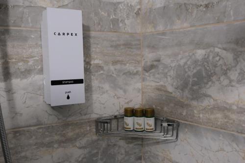 a wall with three bottles of oil on a shelf at Şahin Tepesi Suite Otel in Trabzon