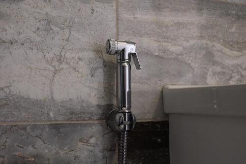 a water hose hooked up to a toilet in a bathroom at Şahin Tepesi Suite Otel in Trabzon
