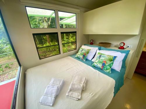 a small bedroom with a bed with two pillows at Jungle Bus, 5 min drive to PlayaLinda, 15 to Dominical, Wifi Starlink in Quepos