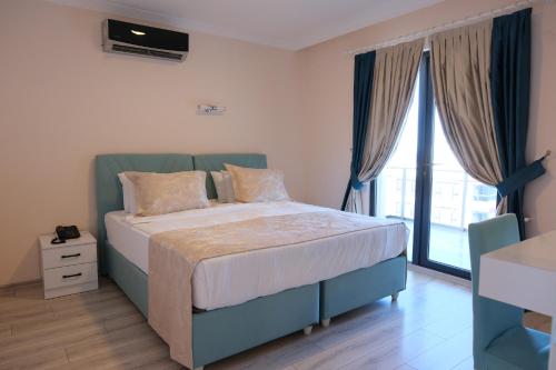 a bedroom with a bed and a large window at Şahin Tepesi Suite Otel in Trabzon