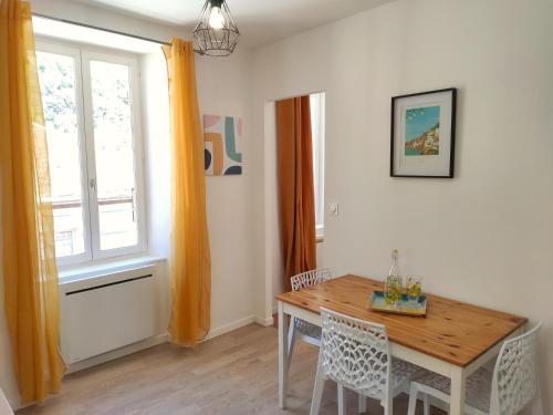 une salle à manger avec une table et des chaises et une fenêtre dans l'établissement Le Bellevue - Focalimmo, à Foix