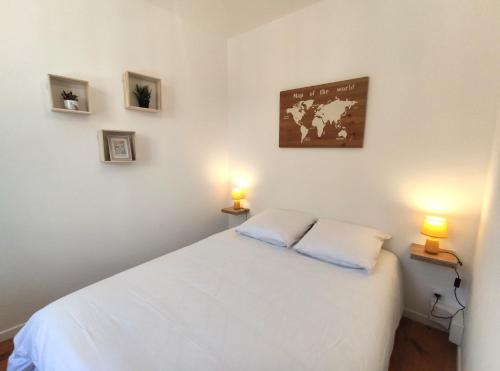 a bedroom with a white bed with two lamps at Le Bellevue - Focalimmo in Foix