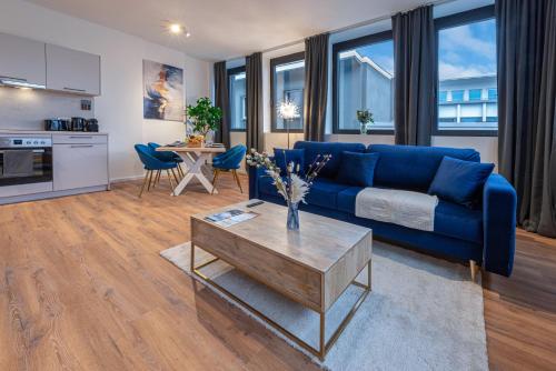a living room with a blue couch and a table at Neues und zentrales Apartment in der Essener Innenstadt von STAY YOUR WAY in Essen