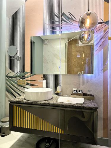 ein Badezimmer mit Waschbecken und großem Spiegel in der Unterkunft ARN Boutique Hotel in Focşani