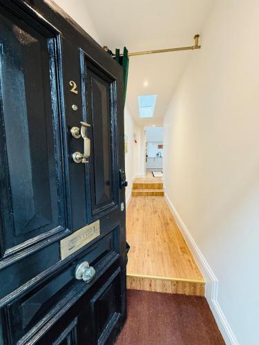 a room with a black door and a hallway at Spacious, Worcester city centre 2 bedroom apartment in Worcester