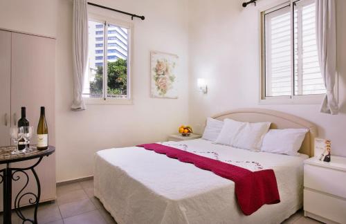 a bedroom with a bed with a red blanket on it at City Center Apartments in Haifa