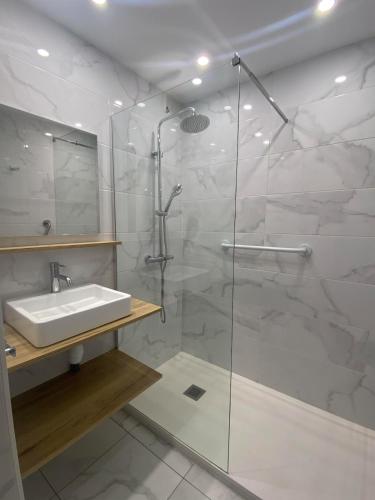 une salle de bain avec une douche en verre et un lavabo dans l'établissement BEACH apartment 4 people, à Canet