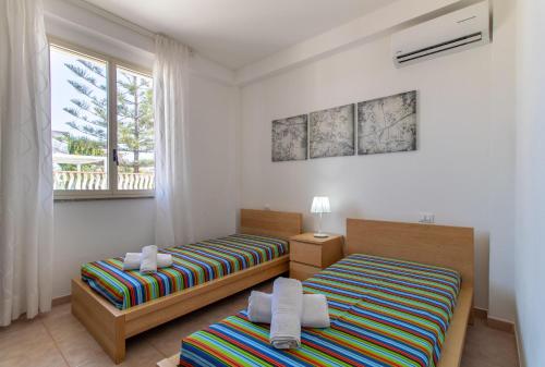a bedroom with two beds and a window at Casa Cycas in Santa Maria Del Focallo