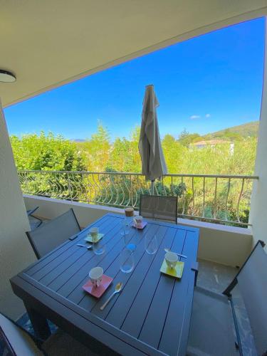 une table bleue sur un balcon avec un parasol dans l'établissement T3 - 5 min du Centre Ville et Plage - Parking, à Sanary-sur-Mer