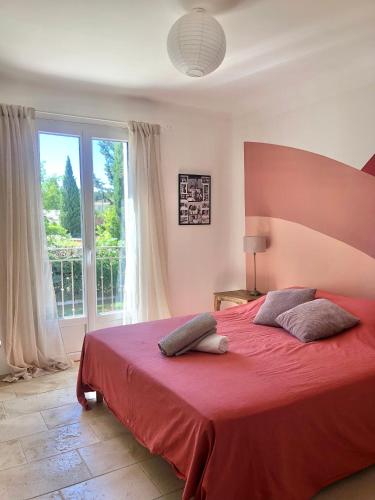 - une chambre avec un lit rouge et une grande fenêtre dans l'établissement Hope, villa à Aix en Provence, à Aix-en-Provence