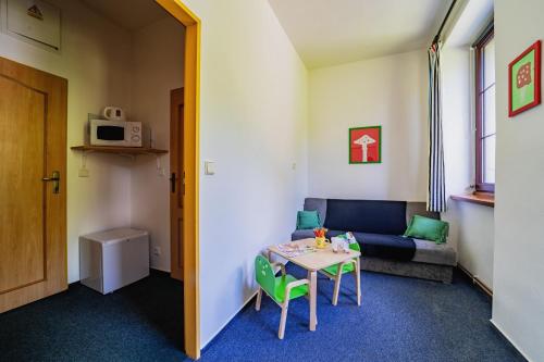 a living room with a couch and a table at Penzion Šumavous in Vimperk