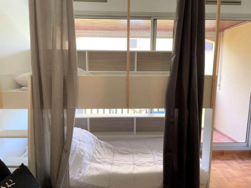 une chambre avec un lit superposé avec des draps blancs dans l'établissement Studio CAP D'AGDE CT090-209, au Cap d'Agde