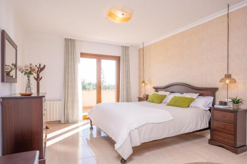 a bedroom with a large white bed and a window at Can Albons in Portocolom