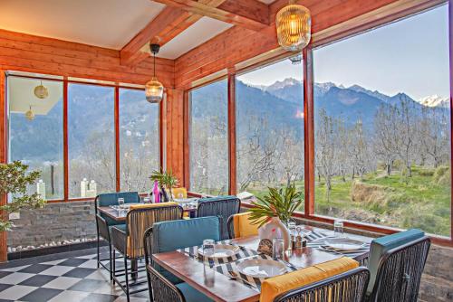 a restaurant with a view of the mountains at Echor Himalayan Aurum Manali, Heating & Cooling in Manāli
