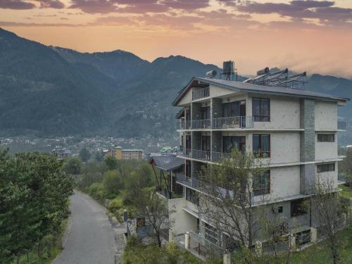 a building on a hill next to a road at Echor Himalayan Aurum Manali, Heating & Cooling in Manāli