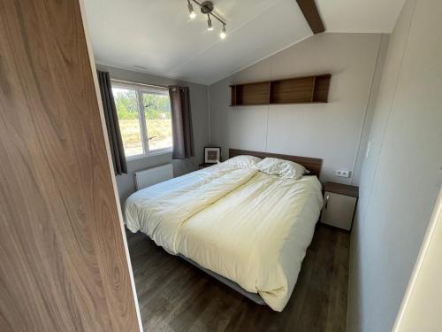 a small bedroom with a bed and a window at Hoeve Twente - De Buizerd in Heythuysen