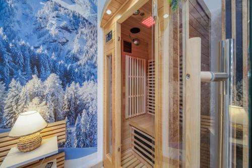 een inloopdouche in een kamer met een muurschildering bij Le Montblanc spa in Roanne