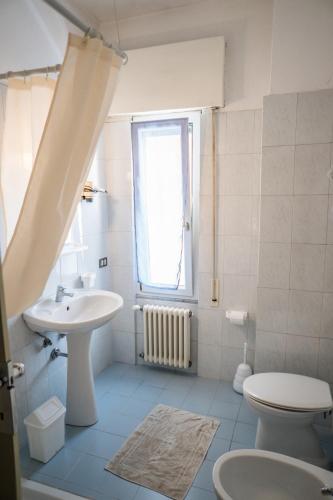 a bathroom with a sink and a toilet and a window at Hotel Maremola in Pietra Ligure